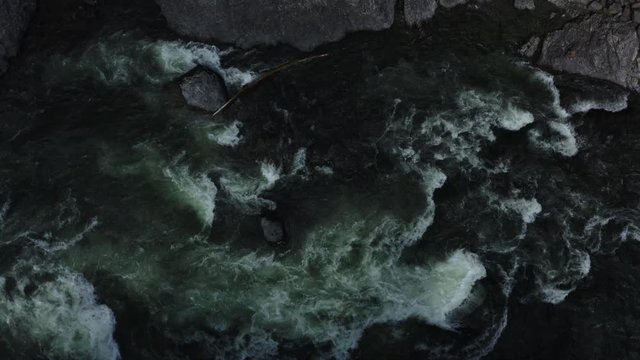 Aerial Altay turbulent stony river top view lifting up the lighting change 