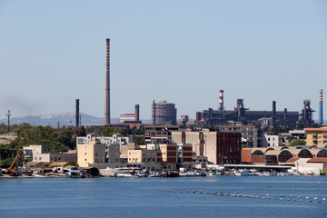 Fototapeta na wymiar ArcelorMittal steelworks company (formerly Ilva) with neighborhood Tamburi of Taranto, Puglia, Italy 