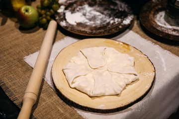 Raw pie with cottage cheese on a wooden board.