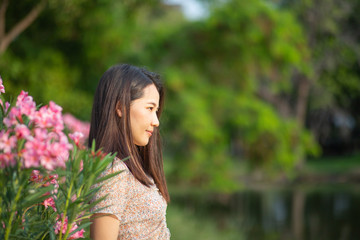 Naklejka premium Beautiful Asian woman alone in the park with pink flowers