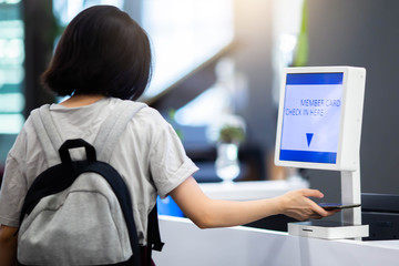 Selective focus to member card reader machine to check in with hand using smartphone to scan QR code for register.