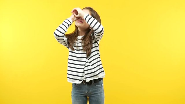 Funny little child girl doing the gesture of a spyglass