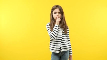 Funny little child girl keeping a secret or asking for silence