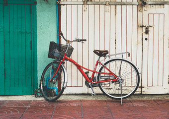 Fototapeta na wymiar Red bicycle parked in front of white and green wall