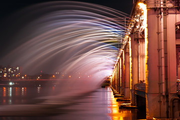 Fototapeta na wymiar Amazing fantastic colorful fountain with blight at the bridge,