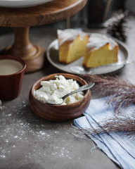 Ricotta. Curd cheese in a small wooden bowl on the table. Ricotta for making a pie. Farm product.
