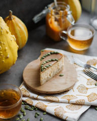 Pumpkin cheesecake garnished with pumpkin seeds. Sugar caramel. Spiral. Still life with pumpkins and cake. Tea cups.