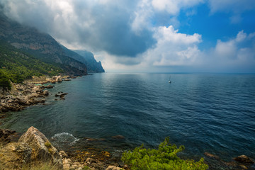 Fototapeta premium Sea and mountains in the clouds. Beautiful sea natural landscape, travel.