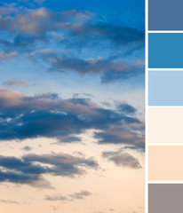 Beautiful dramatic gray clouds in the blue sky at orange sunset. Shades and tones of pink and blue...