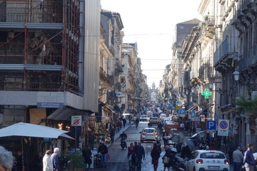 Sehr geschäftige Straße mit Fußgängerzone in der Stadt . Viele Leute und viele Geschäfte . Europe street scene with many peopla cars and malls . Feierabendverkehr in Italien . Nicht verkehrsberuhigt .