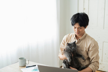 One man working remotely and a cat.