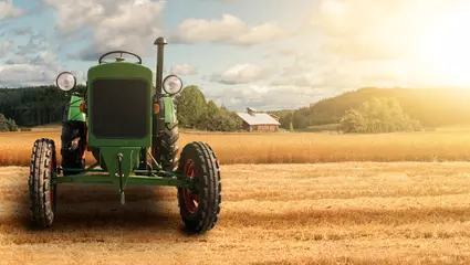 Rolgordijnen Old tractor in the field near the farm © scharfsinn86