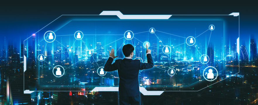 Business man using futuristic people network screen on night city technology background