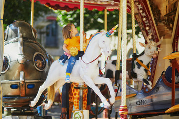Toddler having fun on vintage French merry-go-round in Paris © Ekaterina Pokrovsky