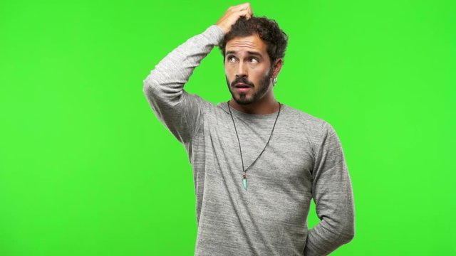 young man on chroma green screen worried and overwhelmed