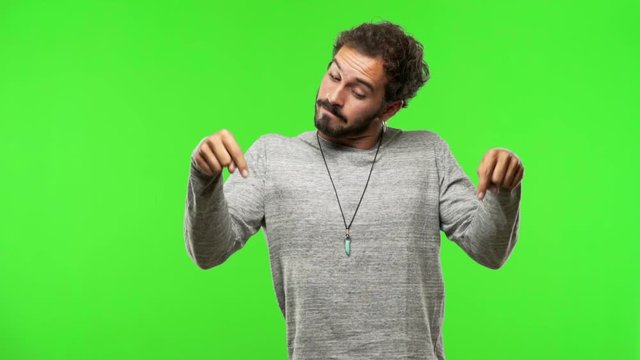 young man on chroma green screen pointing down