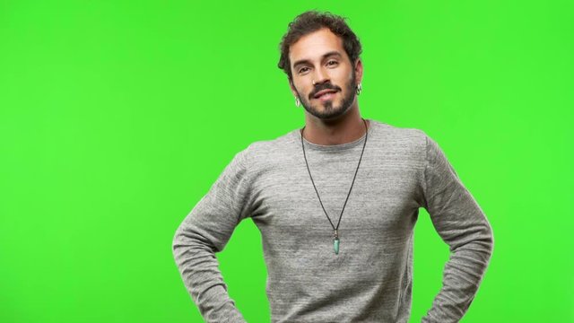 young man on chroma green screen with hands on hips