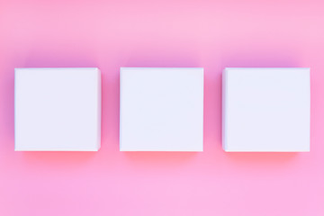 White boxes on a pink background. Jewelry boxes.Concept.