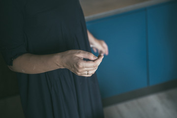 Female hand while cooking in the kitchen. Girl in a blue dress prepares a romantic dinner for her beloved.