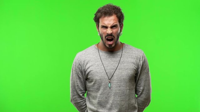 young man on chroma green screen screaming angry