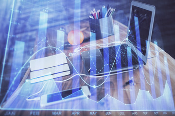 Stock market graph on background with desk and personal computer. Double exposure. Concept of financial analysis.