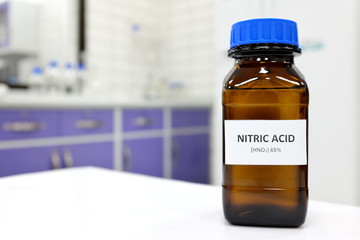 Selective focus of strong Nitric acid solution in brown amber bottle. Blur white laboratory...