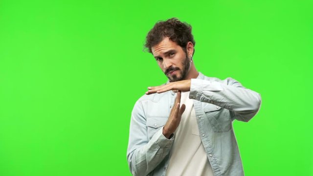 young man on chroma green screen making a timeout gesture