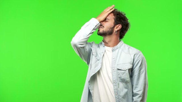 young man on chroma green screen forgetful, realize something
