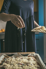 Hand with cheese. Preparing of pizza at the home. Cheese for the homemade pizza. 
Pizza time.