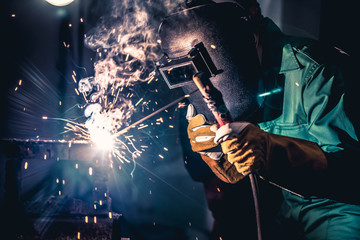 Metal welding steel works using electric arc welding machine to weld steel at factory. Metalwork...
