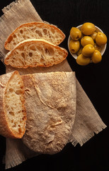 Ciabatta. Fresh italian ciabatta bread with herbs, olive oil and olives, copy space.