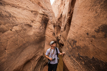 Young man hiking in narrow canyon Utah
