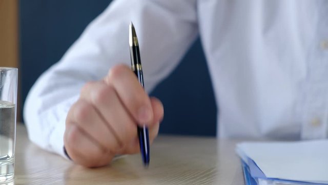 Boss or teacher knocks on the table with a pen urging silence