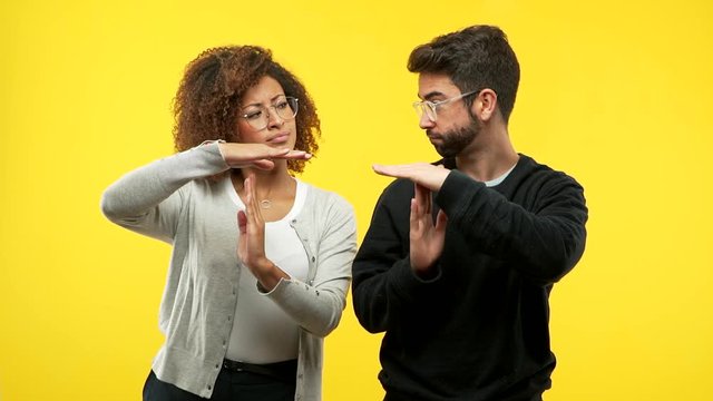 young black woman and caucasian man making a timeout gesture