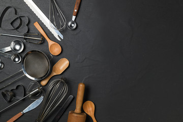 Kitchen utensils for pastries on black table and copy space,