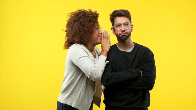 young black woman and caucasian man whispering gossip undertone