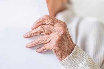 Nahaufnahme Hand, alte Frau mit faltigen Händen liest einen weißen Brief
