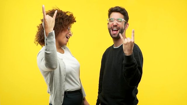 young black woman and caucasian man doing a rock gesture
