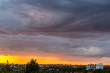 Very beautiful sunset in the city or village. Pink-orange sky with clouds.