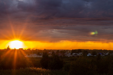 Very beautiful sunset in the city or village. Pink-orange sky with clouds.