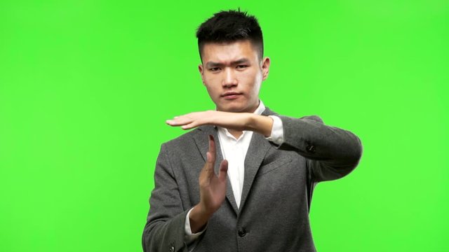 Young chinese business man making a timeout gesture