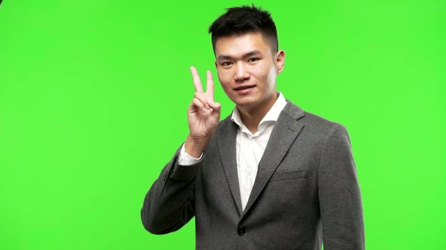 Young chinese business man fun and happy doing a gesture of victory