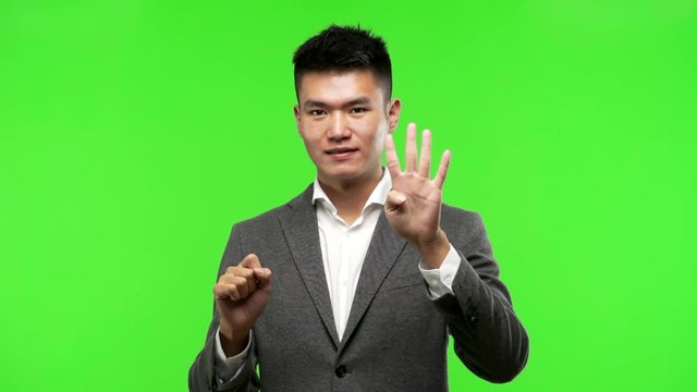 Young chinese business man showing number seven