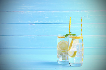 Lemon juice mixing soda no-alcohol with slide lemon in the glass on blue wooden background with...