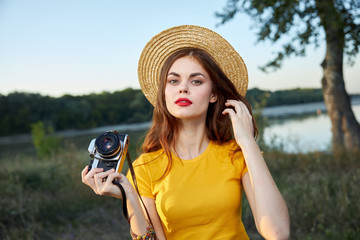 Woman in a hat with a camera in her hands red lips attractive look nature