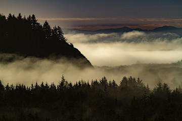 A fog banket laying in a valley near Ilwaco, Washington, with the Oregon coast range mountqins in the background.