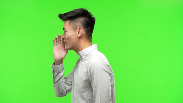Young handsome chinese man whispering gossip undertone