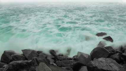 A Colorful Ocean Sunset Sky as a Gentle Wave Rolls to Shore
