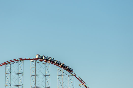 A roller coaster at the top of a hill