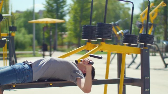 Man trining pectoral muscules in park